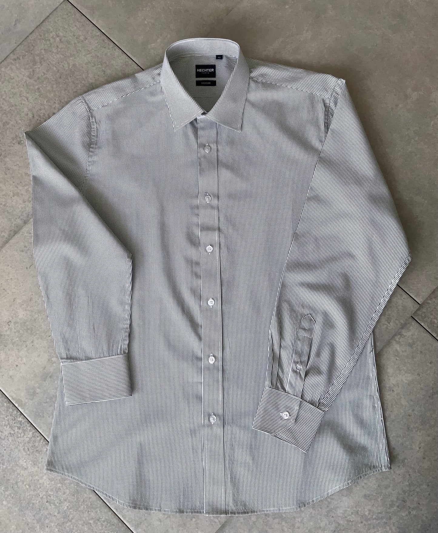 Classic style meets modern tailoring with Liberty black and white check business shirt. Designed for versatility and comfort, this shirt features a crisp check pattern that transitions effortlessly form the boardroom to after hours. Crafted from a breathable cotton/polyester blend, it delivers all day wearability with a polished, professional finish. The structured collar and button up design make it ideal for pairing with tailored trousers, chinos or layered under a blazer.