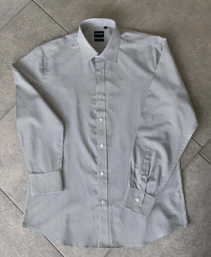 Classic style meets modern tailoring with Liberty black and white check business shirt. Designed for versatility and comfort, this shirt features a crisp check pattern that transitions effortlessly form the boardroom to after hours. Crafted from a breathable cotton/polyester blend, it delivers all day wearability with a polished, professional finish. The structured collar and button up design make it ideal for pairing with tailored trousers, chinos or layered under a blazer.