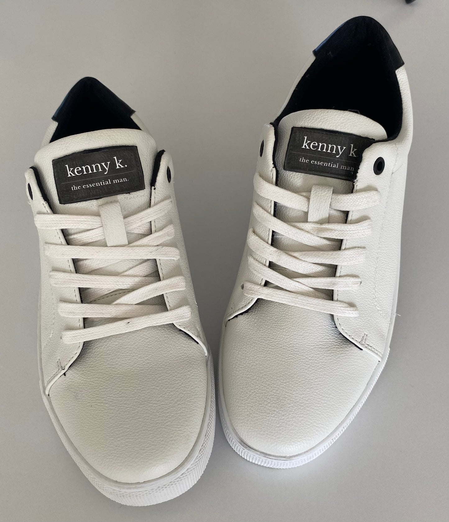 Introducing the essential white sneaker by Connor &amp; Kenny K. Made from high-quality faux leather, these sneakers are stylish and a basic essential for business and leisure. With their classic white design, they are perfect for any outfit and any occasion. Upgrade your footwear game with these must-have sneakers.
