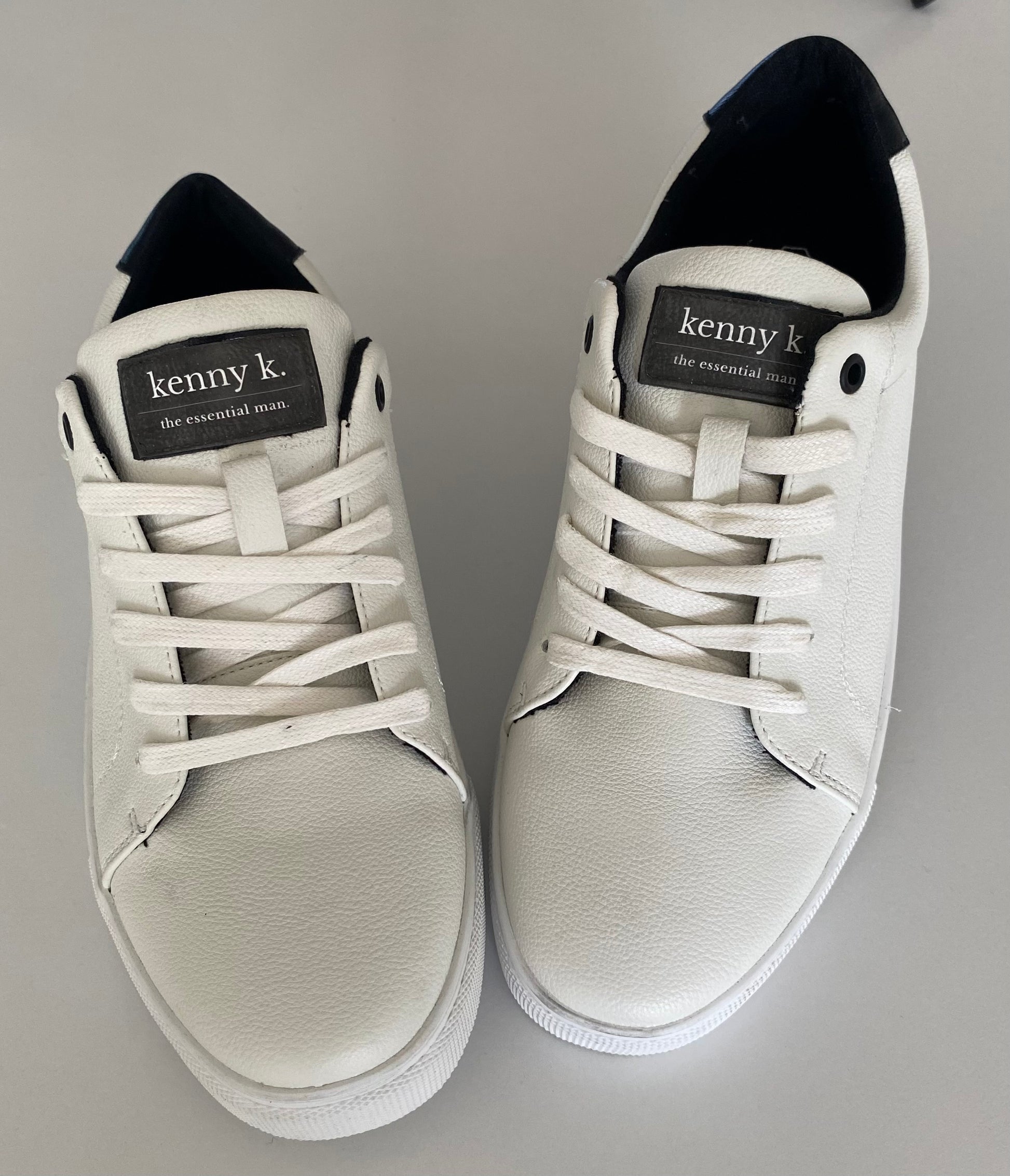 Introducing the essential white sneaker by Connor &amp; Kenny K. Made from high-quality faux leather, these sneakers are stylish and a basic essential for business and leisure. With their classic white design, they are perfect for any outfit and any occasion. Upgrade your footwear game with these must-have sneakers.